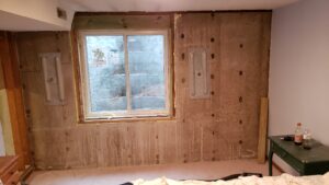 Basement bedroom remodel under construction after egress installation.