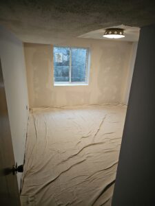 Basement bedroom remodel under construction after egress installation.