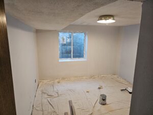 Basement bedroom remodel under construction after egress installation.