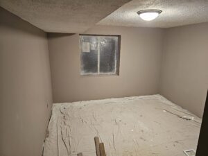 Basement bedroom remodel under construction after egress installation.