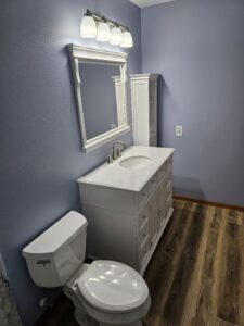 bathroom remodel with white cabinets and vinyl plank flooring