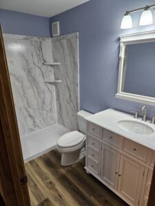 bathroom remodel with white cabinets and vinyl plank flooring