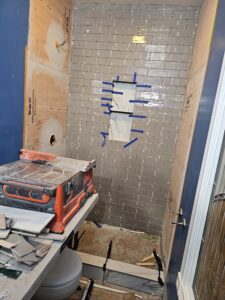 gray subway tile shower wall under construction.