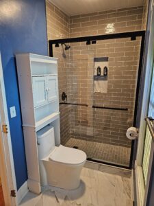 Gray subway tile shower with glass door.