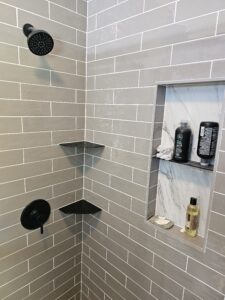 Gray subway tile shower with glass door.