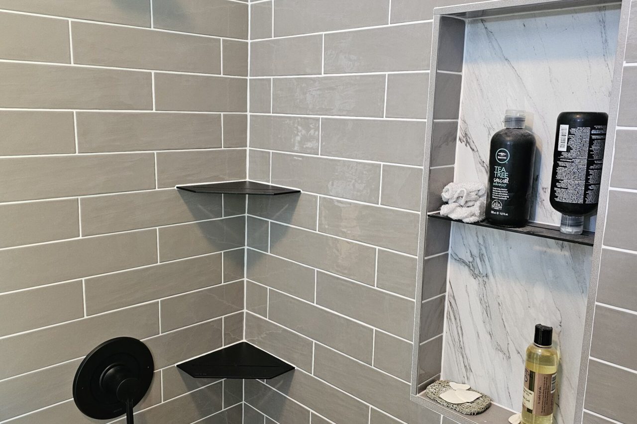 Gray subway tile shower with niche